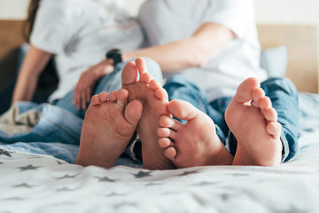 legs of a loving couple lying on the bed