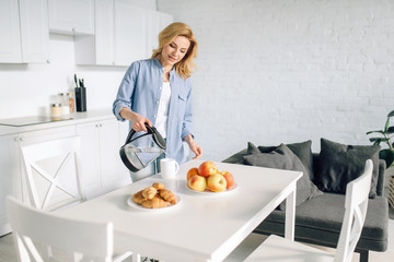 Happy woman cooking breakfast on the kitchen