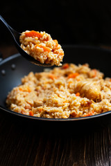Traditional homemade Uzbek pilaf or plov in iron frying pan. Uzbek cuisine. Close Up. Selective Focus.
