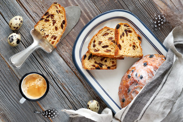 Easter Bread (Osterbrot in German). Top view of traditional fruity bread on rustic wood  with fresh leaves and quail eggs