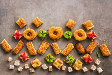 Pattern of Middle Eastern sweets on a brown background. Traditional Arabic dessert baklava. Ramadan. Top view.