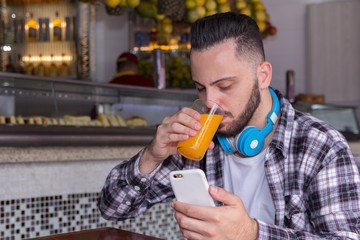 Customer drinking juice and reading articles and posts on his social media page outside of...