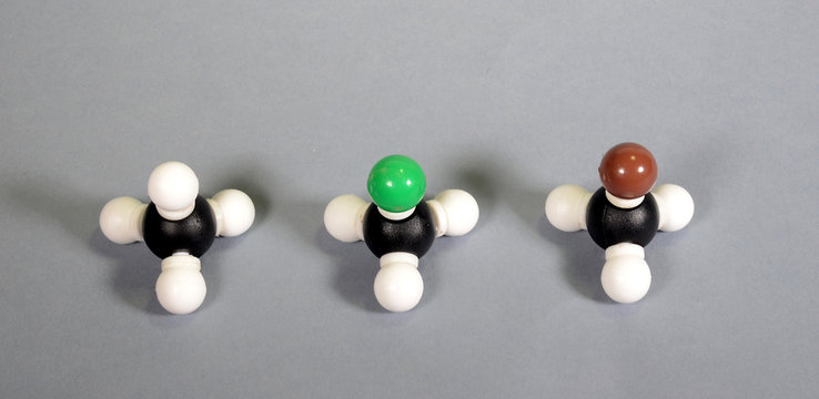 Three molecule models of methane two woith substitutions by halogens, from left: Nnormal methane, clormethane, and brom methane.