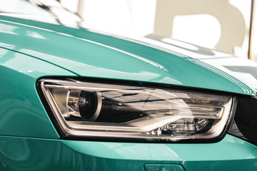 Closeup headlights of a modern Mint color car. Detail on the front light of a car. Modern and...