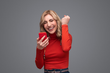 Woman with smartphone celebrating success