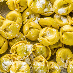 raw ravioli tortellini on the table with flour and rolling pin. cooking healthy italian home cooking