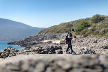 Fototapeta premium woman with backpack and camera walking near the sea