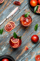 Blood orange juice with ice and orange slice. Fresh summer cocktail with red oranges in a glass. Fresh cocktail. Nonalcoholic blood orange cocktail in a glass.