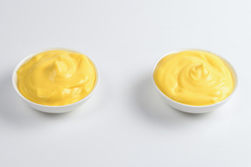 Cheese sauce in white plate on white background.