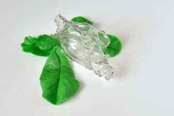 Glass rose Bud and plastic chocolate leaves.