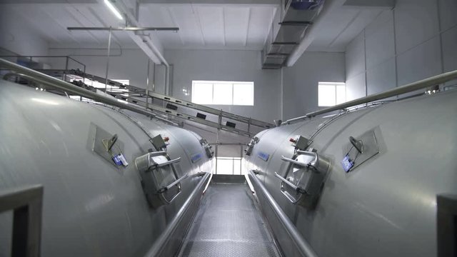 Huge tanks for storing and fermenting milk. Pipeline in modern dairy factory