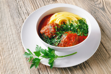beef cutlets with pasta and tomato sauce decorated with parsley