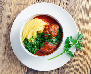 minced beef cutlets with spaghetti and tomato sauce decorated with parsley