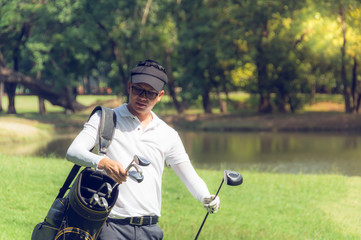 Golfers carry bags that contain many golf clubs, ready for the game, to sport and recreation...