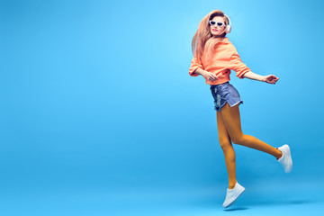 Young easy-going happy hipster Woman dance Having Fun in Stylish fashion headphones. Beautiful excited Girl laughing enjoy music in summer Trendy outfit. Creative art dancing fashionable concept
