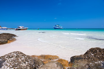 Rock on the beach with blue sea and sky.