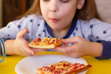 Little girl eating pizza
