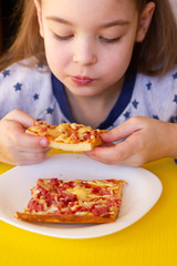 Little girl eating pizza