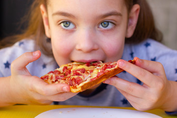 Little girl eating pizza