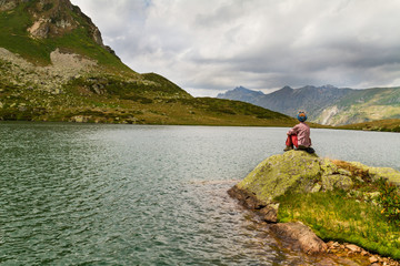 Fototapeta na wymiar girl on the shore of a mountain lake