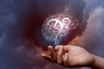 A digital brain model with gears inside hanging above a hand.