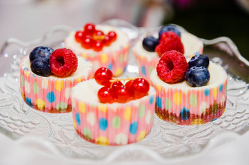 some cupcakes with berries on a plate