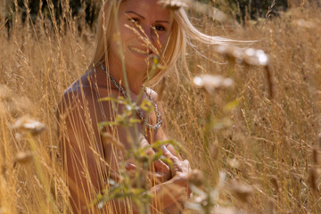 Junge blonde Frau nackt in einem Feld