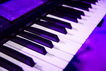 piano keys close up in purple concert light