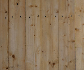 New wooden wall. Big fresh boards with knots. Natural background, wood texture. Vertical structure.