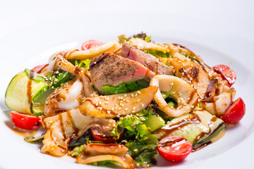 seafood salad with teriyaki sauce in a white plate