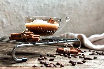 still life with a cup of coffee and coffee beans cinnamon sticks in the living room on a wooden table, the concept of comfort and interior in the Scandinavian style hugg