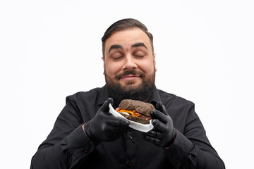 Glad man smelling burger with closed eyes