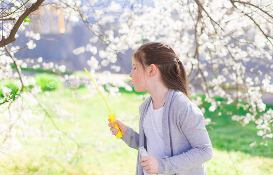  girl, white t-shirt and gray jacket, flowering trees, soap bubbles