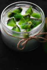 Yogurt with kiwi slices on a black background