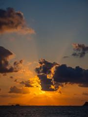 Silhouette of a ferry in the rays of the setting sun with clouds. Koh Phangan Thailand