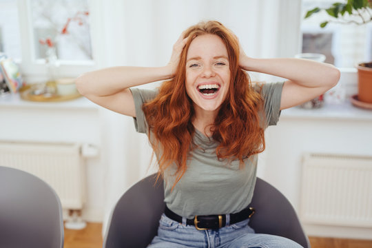 Cute young woman laughing at a hilarious joke