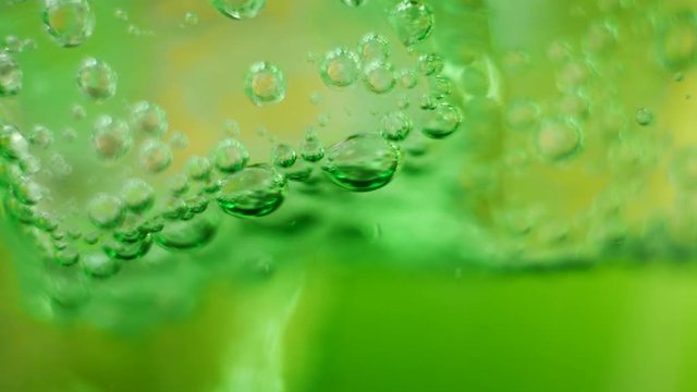 Air Bubbles Inside Glass of Sparkling Green Water. Fresh fizzy summer soda, green cocktail, healthy drink concept