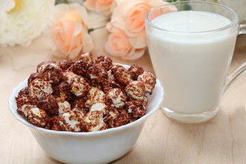 Cup of popcorn and a mug of milk on a wooden table close-up, tasty breakfast and a good start to the day