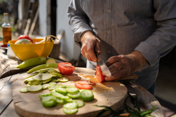 Senior man preparing food outdoors