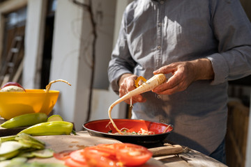 Senior man preparing food outdoors