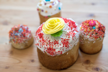 Traditional Russian Easter cake with sugar yellow flower on a wooden table