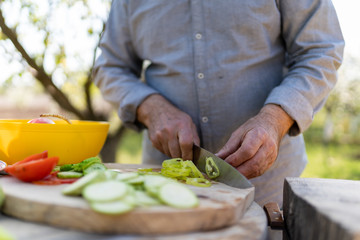 Senior man preparing food outdoors