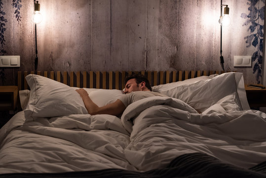 Man sleeping in bed in a modern beautiful bedroom