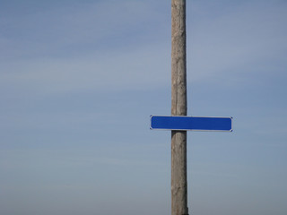 wooden signpost on blue sky