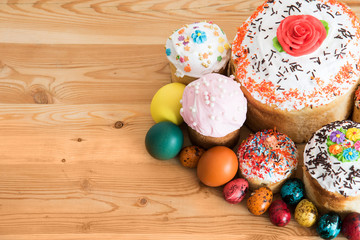 Easter composition with Easter cakes and painted eggs on a wooden background