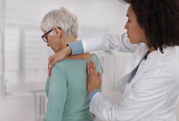 Mature Woman having chiropractic back adjustment. Osteopathy, Physiotherapy, Sport injury rehabilitation concept, holistic care