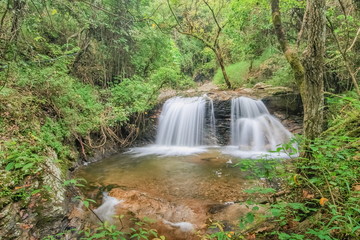 Mae Pan Waterfall, view of silky water flowing around with green forest background, Doi Inthanon, Chiang Mai, northern of Thailand.