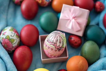 colored easter eggs with pink gift box. top view. egg with flowers