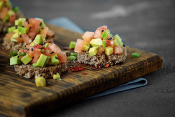 Delicious snacks with bread, avocado and tomato. Close-up. The concept of healthy food, vegetarianism.