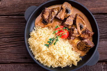 Top view mushroom beef stroganoff in frying pan with couscous